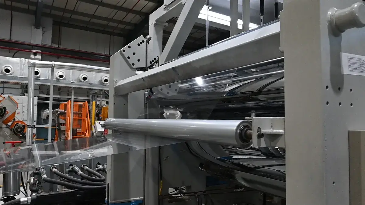 Clear PET sheet running through AVI Global Plast's extrusion line.