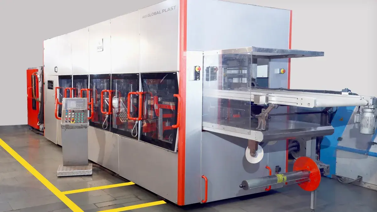 AVI Global Plast's thermoforming machine on the production floor.